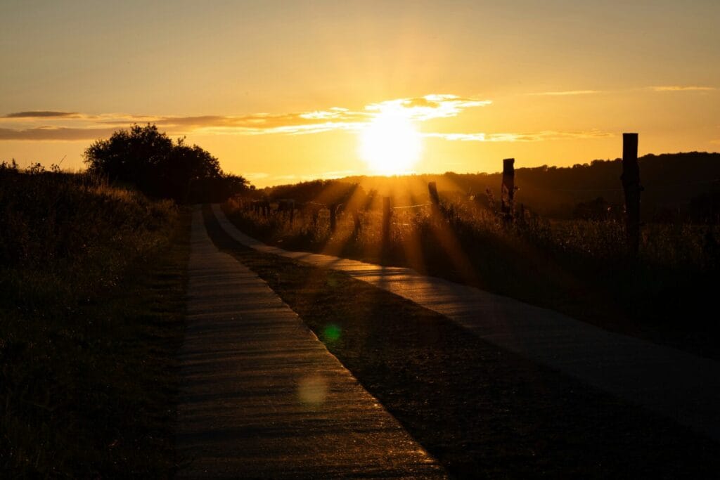 A peaceful sunrise over a winding path representing hope and Jesus as the Way to find real help in God's Word.